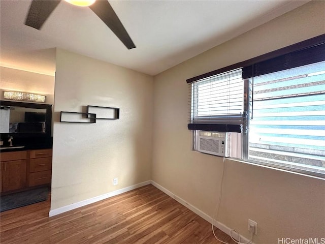 unfurnished room with cooling unit, wood-type flooring, and sink