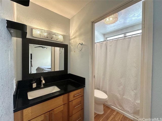 bathroom featuring vanity, hardwood / wood-style flooring, toilet, and walk in shower