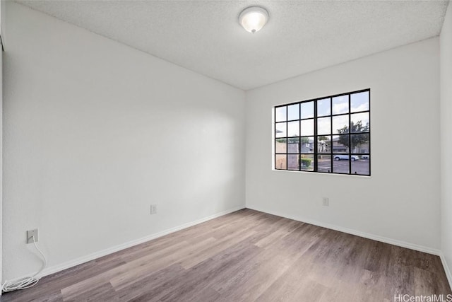 unfurnished room with a textured ceiling and hardwood / wood-style flooring