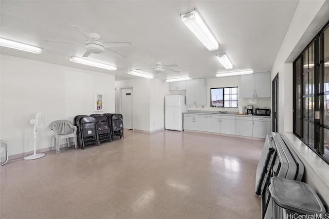 garage with white fridge, ceiling fan, and sink