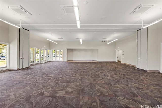 carpeted spare room with vaulted ceiling with beams