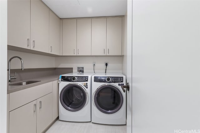 laundry room with washer and dryer, sink, and cabinets