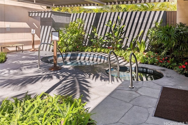 view of patio / terrace with an in ground hot tub