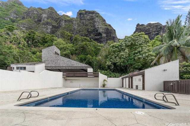 view of swimming pool with a mountain view and a patio area