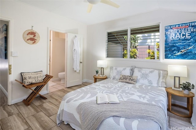 bedroom with ceiling fan, light wood-type flooring, connected bathroom, and vaulted ceiling