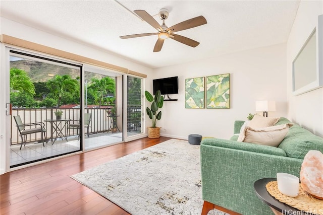 living room featuring wood-type flooring and ceiling fan