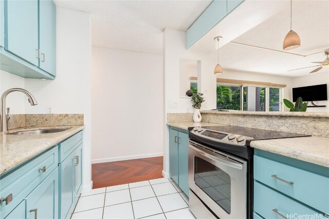 kitchen with electric range, sink, ceiling fan, decorative light fixtures, and light tile patterned flooring