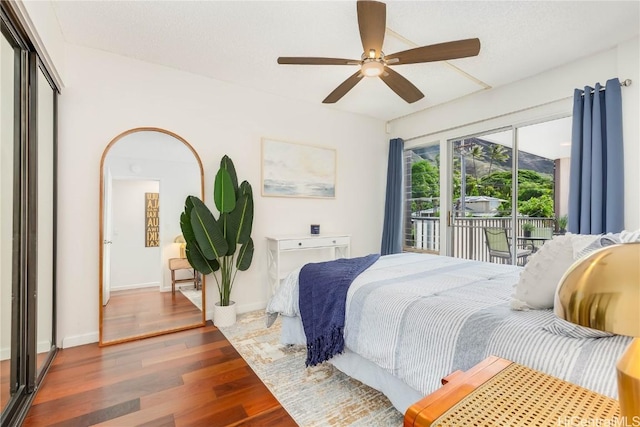 bedroom with ceiling fan, dark hardwood / wood-style floors, and access to exterior