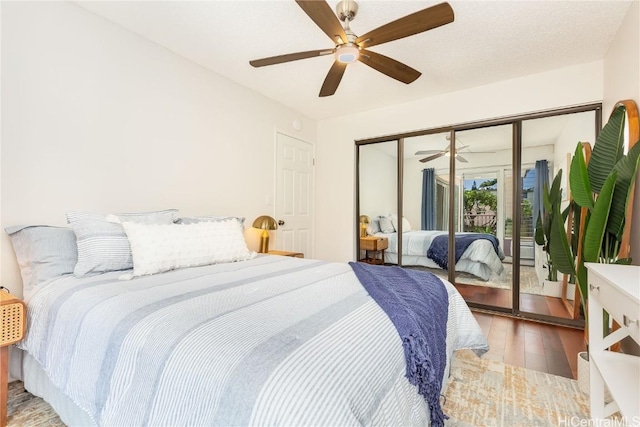 bedroom with ceiling fan, wood-type flooring, access to outside, and a closet