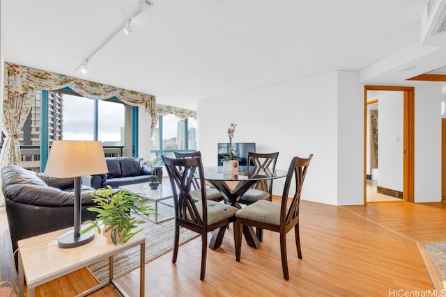 dining room featuring hardwood / wood-style flooring and track lighting