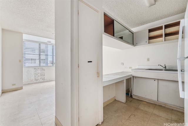 kitchen featuring a textured ceiling and sink