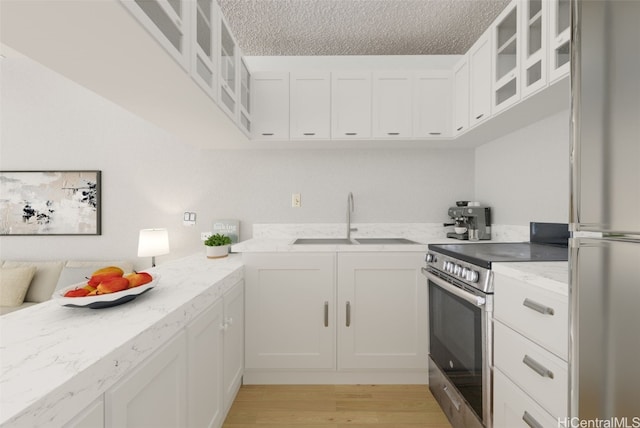 kitchen with sink, white cabinetry, a textured ceiling, and appliances with stainless steel finishes