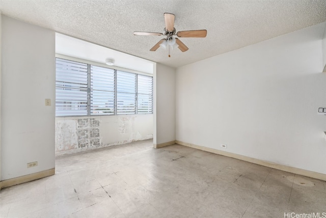 empty room with ceiling fan and a textured ceiling