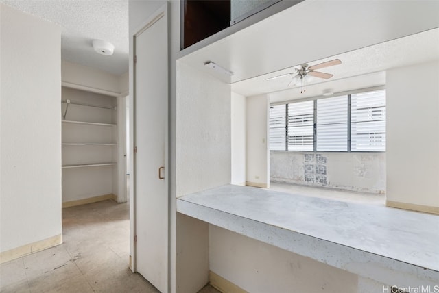 interior space with ceiling fan and a textured ceiling