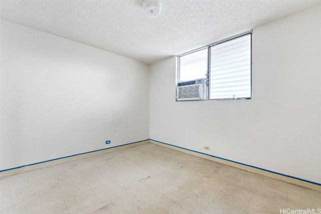 empty room featuring cooling unit and a textured ceiling