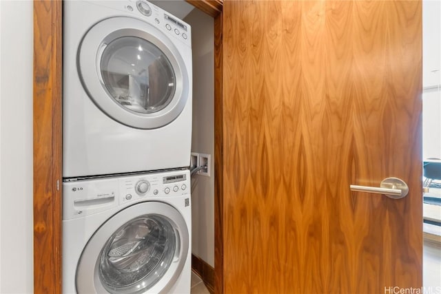 laundry room with tile patterned flooring and stacked washer and clothes dryer