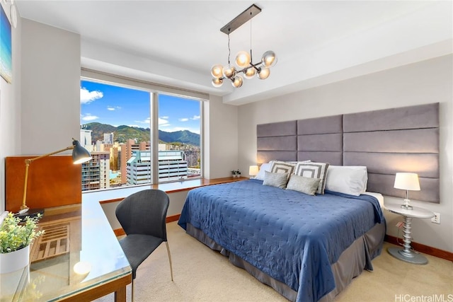 bedroom featuring a mountain view, light carpet, and a chandelier