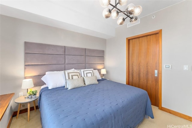 bedroom with a notable chandelier and light colored carpet