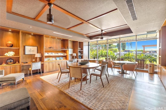 dining area featuring a textured ceiling, light wood-type flooring, ceiling fan, and built in shelves