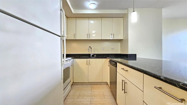 kitchen with sink, cream cabinets, dark stone counters, decorative light fixtures, and white appliances