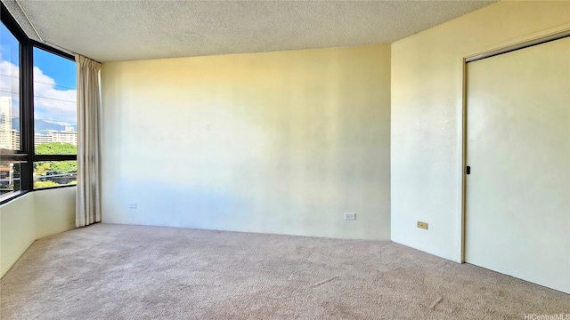 2499 Kapiolani Blvd Unit 401, Honolulu, HI 96826 - spare room with carpet, a textured ceiling, a wall of windows, and a city view