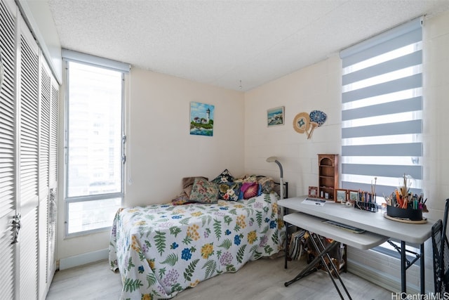 bedroom with light hardwood / wood-style floors and a textured ceiling