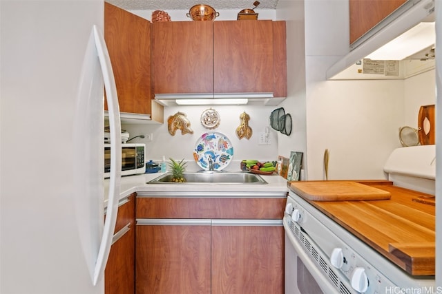 kitchen featuring white appliances and a textured ceiling