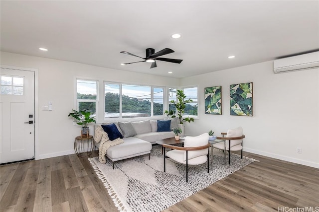 living room with a wall unit AC, plenty of natural light, and hardwood / wood-style flooring