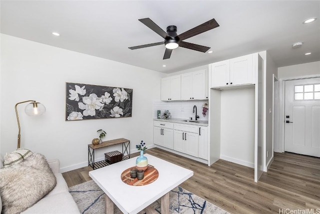 living room with ceiling fan, wood-type flooring, and sink