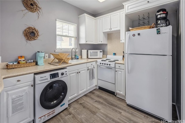 kitchen featuring white cabinetry, sink, light hardwood / wood-style flooring, washer / clothes dryer, and white appliances