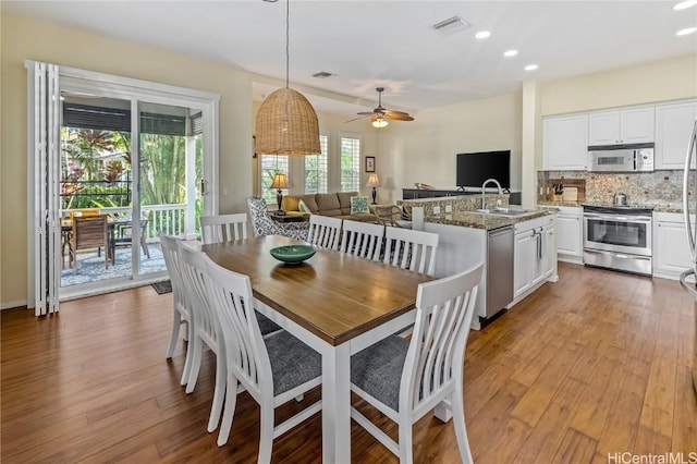 dining space with light hardwood / wood-style flooring, a wealth of natural light, and ceiling fan