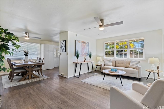 living room with ceiling fan and dark wood-type flooring