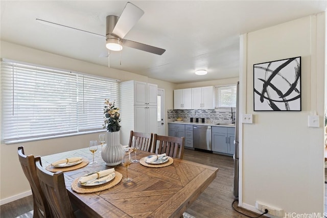 dining area with ceiling fan, dark hardwood / wood-style flooring, and sink