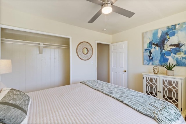 bedroom with a closet, ceiling fan, and wooden walls