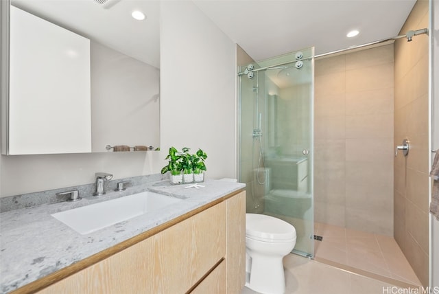 bathroom with tile patterned floors, vanity, toilet, and a shower with shower door