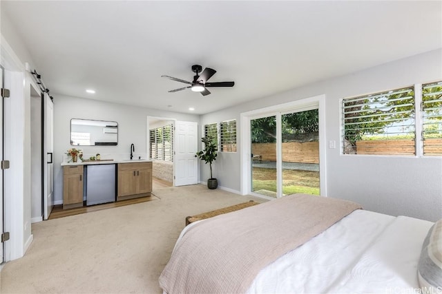 carpeted bedroom featuring stainless steel fridge, access to outside, ceiling fan, sink, and a barn door