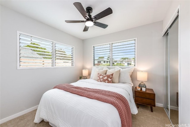 carpeted bedroom with ceiling fan and a closet