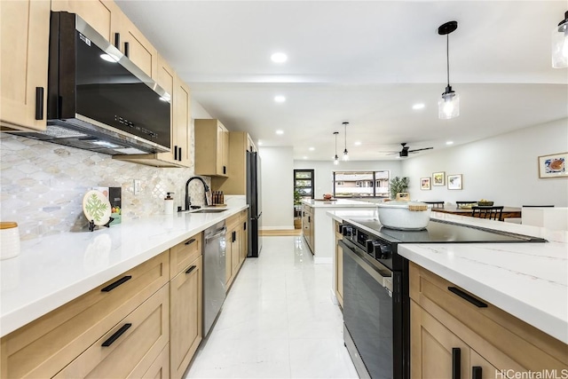 kitchen featuring ceiling fan, sink, decorative light fixtures, and appliances with stainless steel finishes