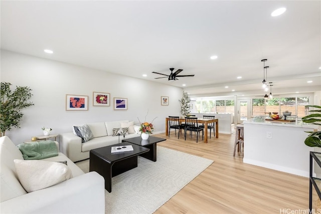 living room with ceiling fan and light hardwood / wood-style floors