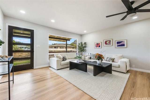 living room featuring light wood-type flooring and ceiling fan