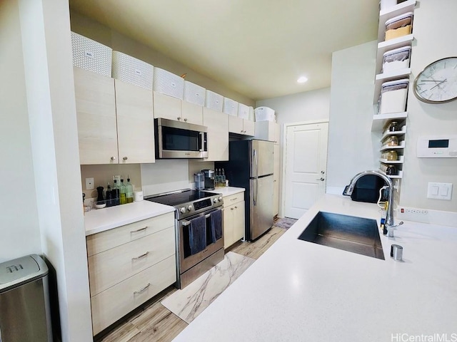 kitchen with white cabinets, sink, light wood-type flooring, and stainless steel appliances