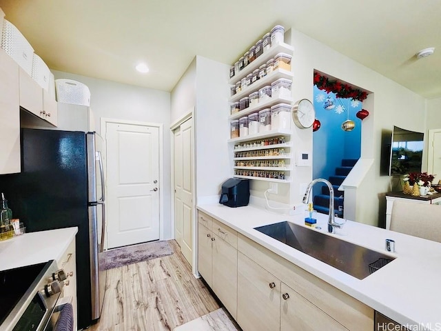 kitchen featuring sink, appliances with stainless steel finishes, and light hardwood / wood-style flooring