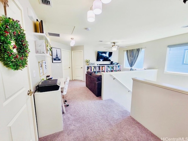 interior space with light carpet and ceiling fan