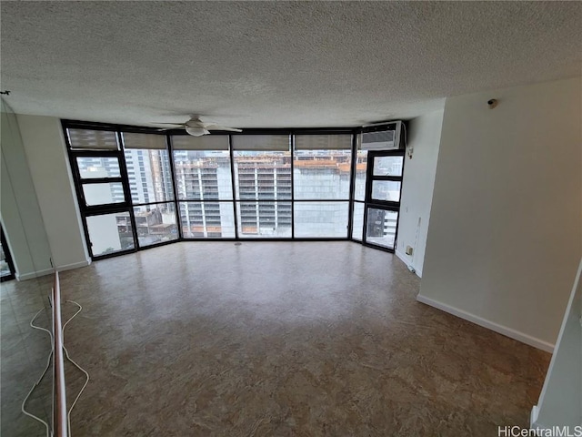 empty room featuring expansive windows, a healthy amount of sunlight, and a textured ceiling