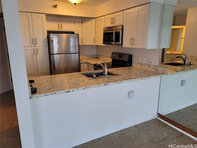 kitchen featuring kitchen peninsula, sink, white cabinets, and stainless steel appliances