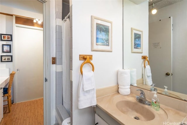 bathroom featuring a shower with curtain, vanity, wood-type flooring, and a textured ceiling