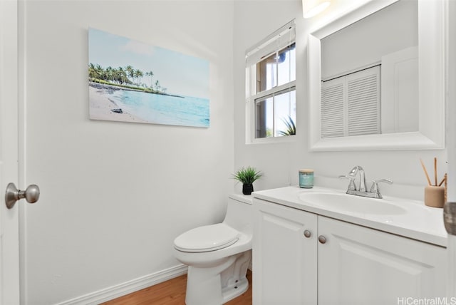 bathroom with hardwood / wood-style flooring, vanity, and toilet