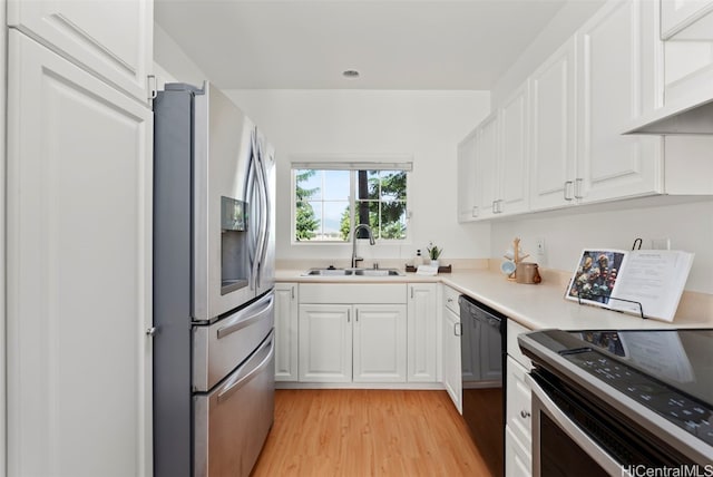 kitchen featuring white cabinetry, dishwasher, range with electric cooktop, stainless steel fridge, and light wood-type flooring