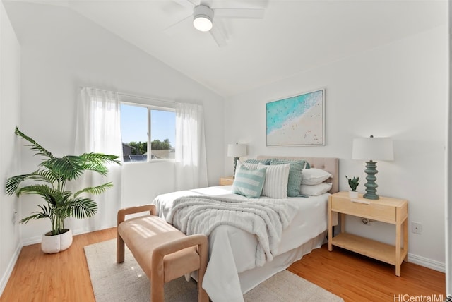 bedroom with hardwood / wood-style floors, vaulted ceiling, and ceiling fan