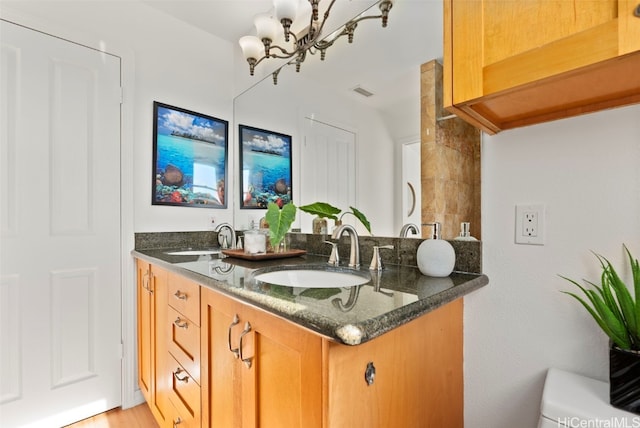 bathroom featuring toilet, vanity, a chandelier, and hardwood / wood-style flooring